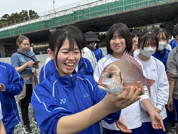 東京家政大附_地引網でかかったタイを両手で抱える中2の生徒